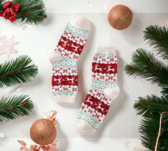 White Christmas socks with vibrant red reindeer and snowflake patterns, styled with festive ornaments for a seasonal look.