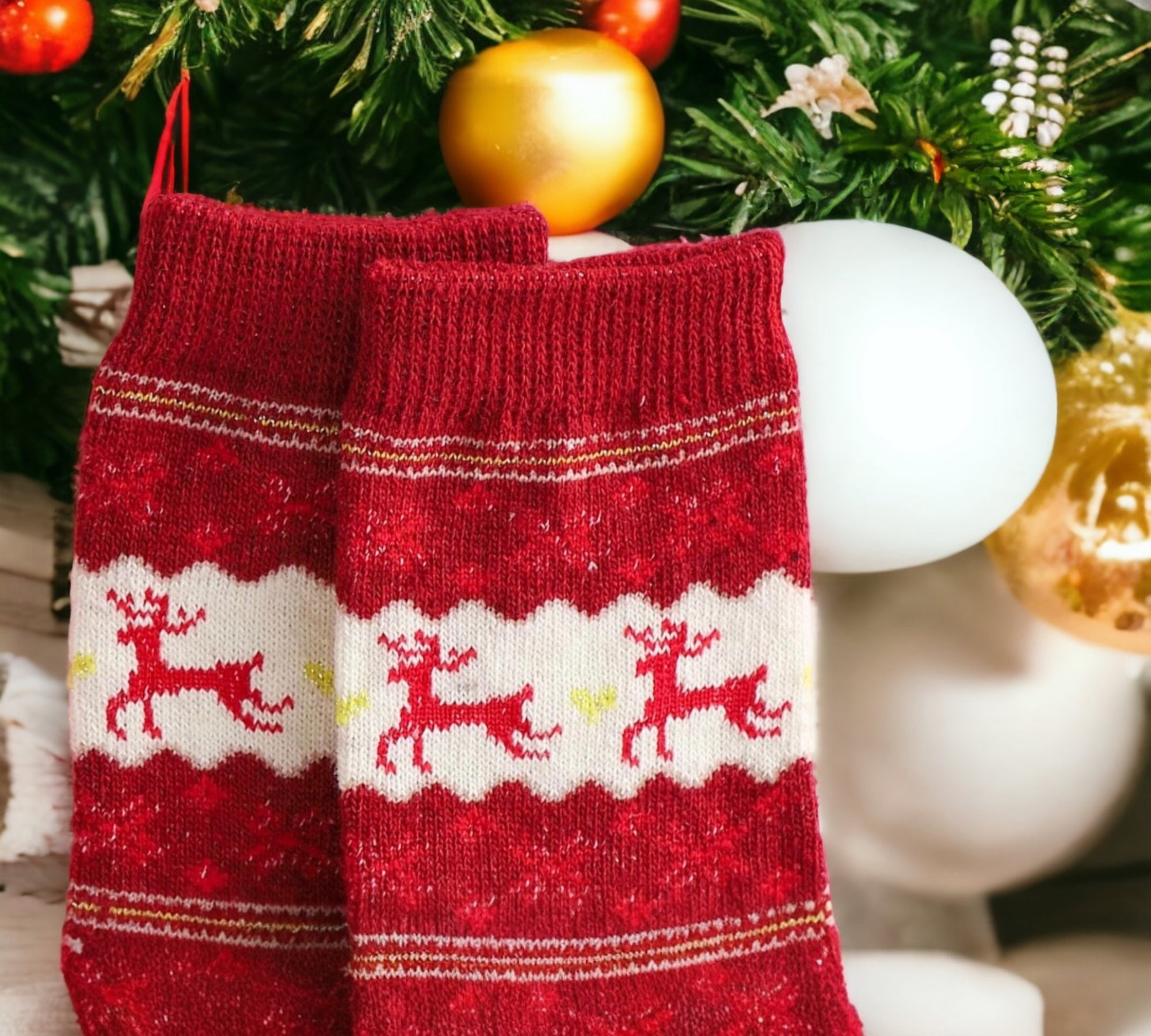 Festive red Christmas socks with white reindeer details displayed hanging on a Christmas tree, perfect as a decorative or gift-ready holiday accessory.
