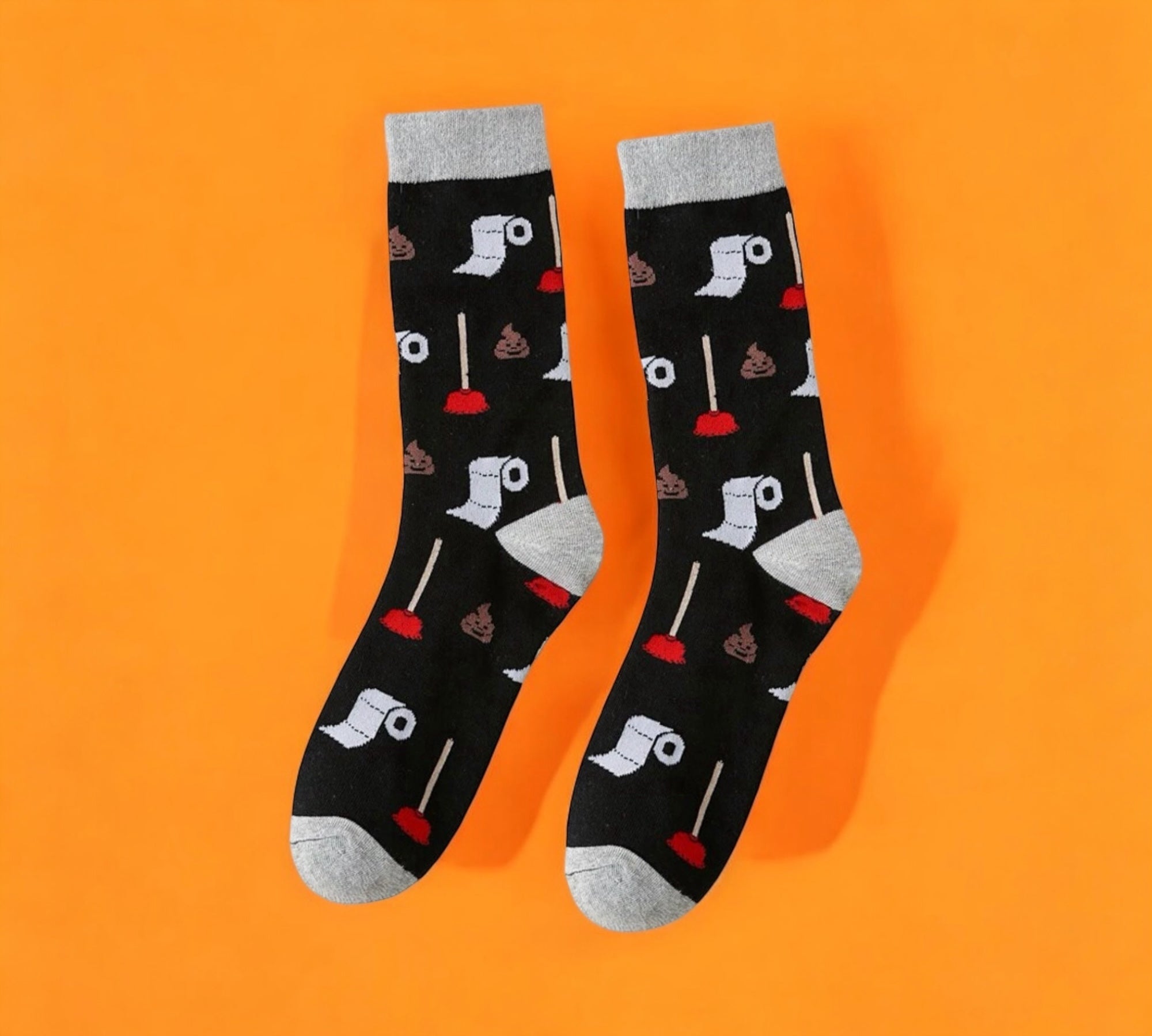 Funny Toilet Paper and Plunger Pattern Socks with a black base and colorful toilet paper roll and plunger design, laid flat on an orange and peach background.