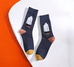 Stylish Ghostly Chic Halloween Socks featuring a white ghost design, mustard toes, and terracotta heels, laid flat on a white and orange background.
